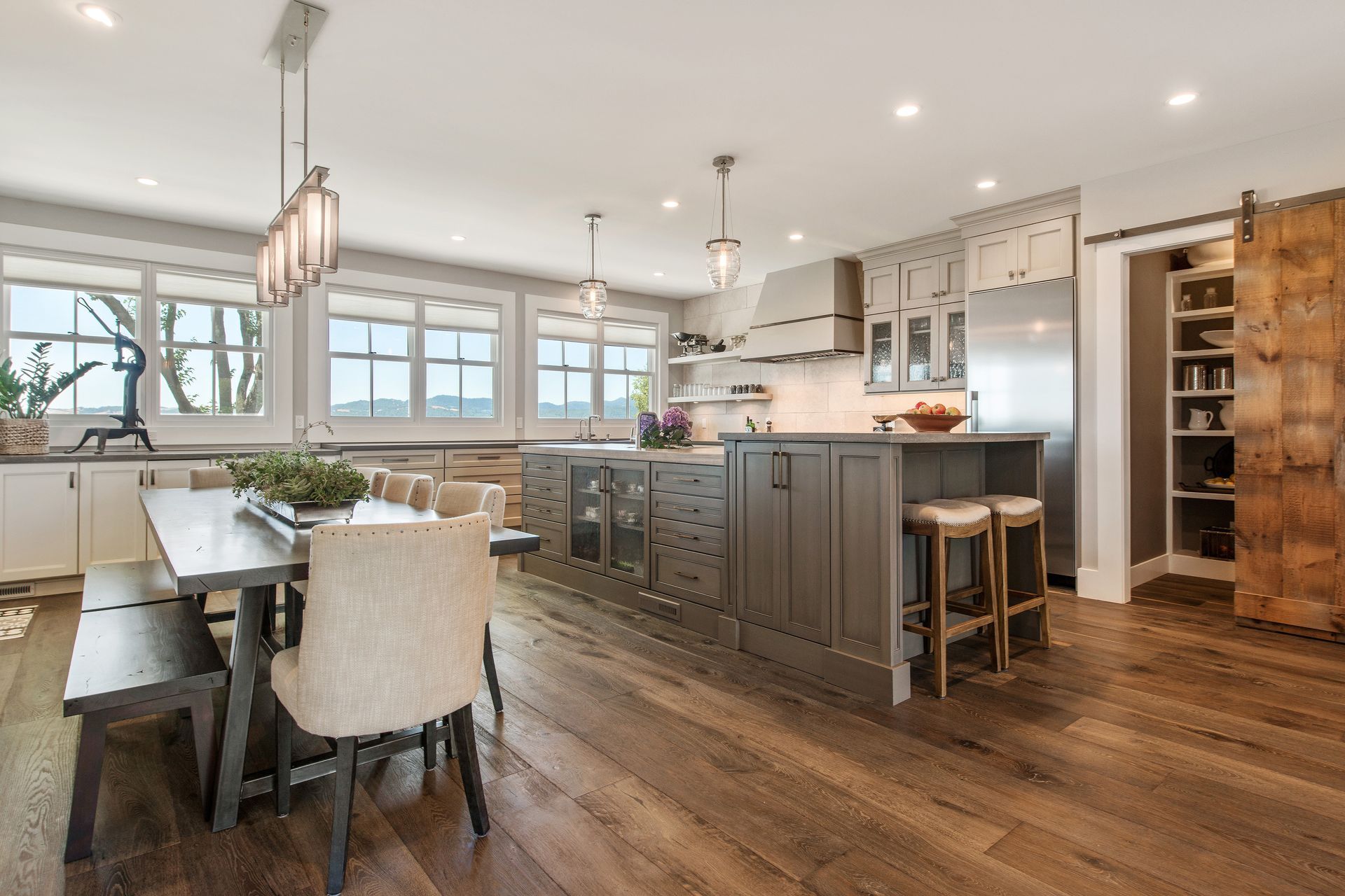 A kitchen with a table and chairs and a sliding barn door.
