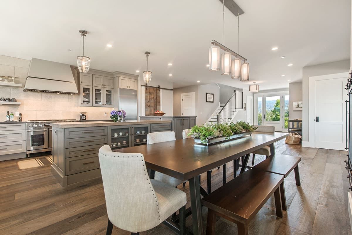 A dining room table with chairs and a bench in a kitchen.