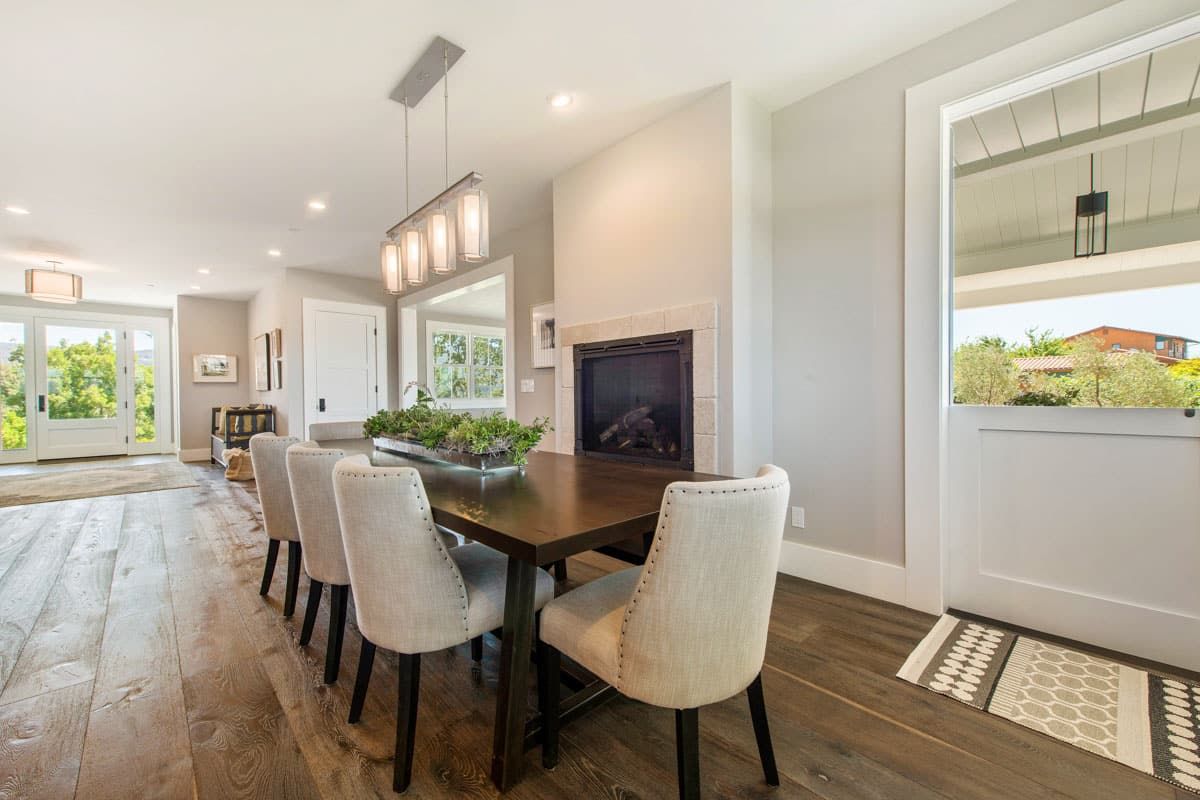 A dining room with a table and chairs and a fireplace.