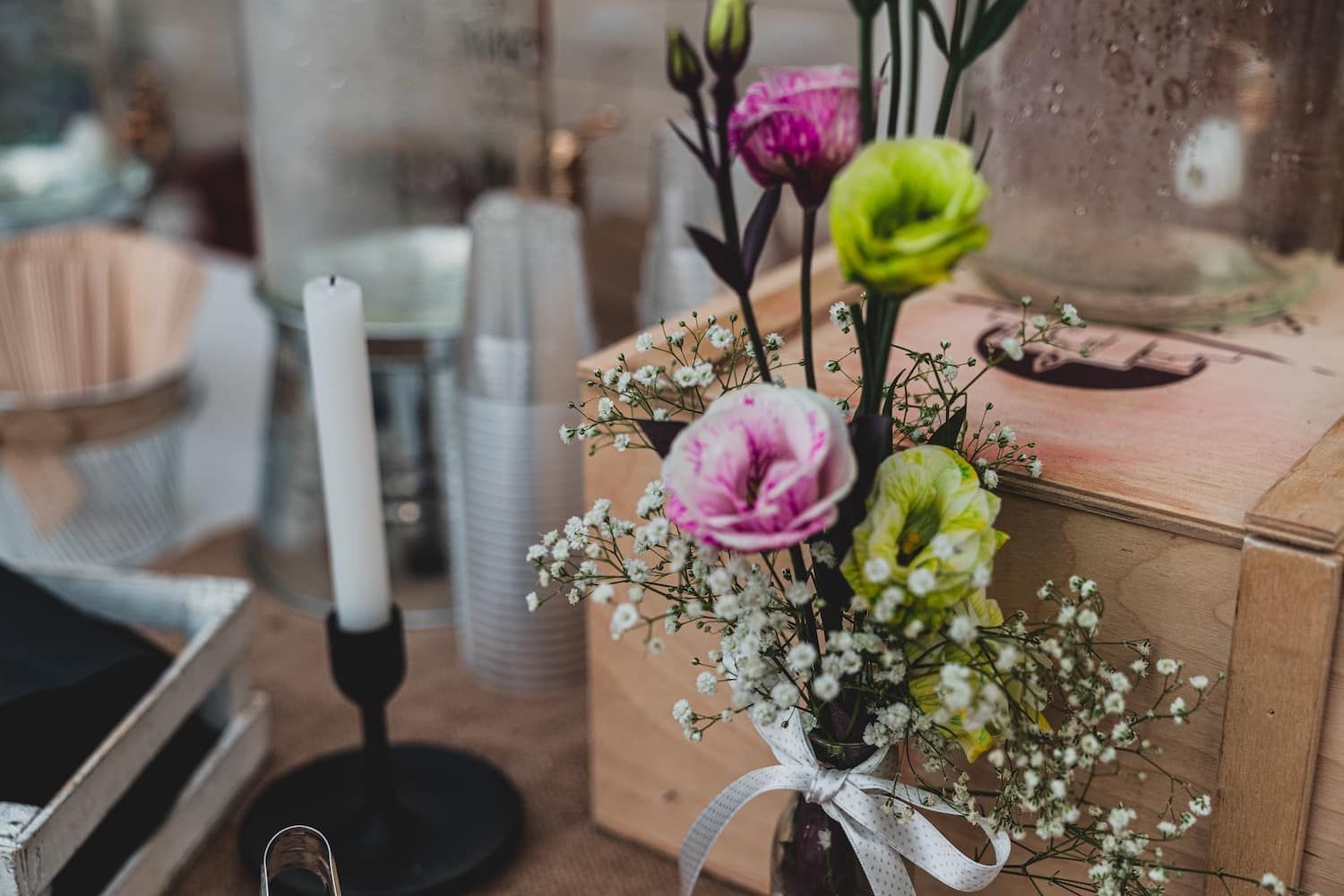 A vase of flowers is sitting on top of a wooden box on a table.