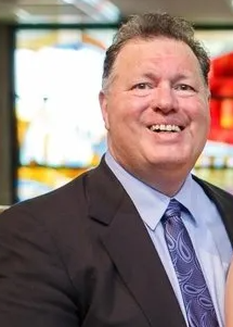 A man in a suit and tie is smiling for the camera.