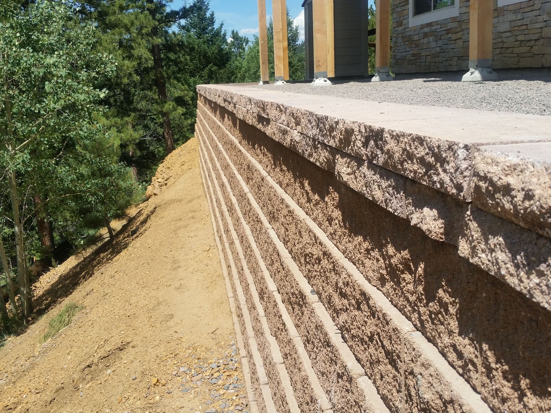 A brick wall is sitting on top of a dirt hill.