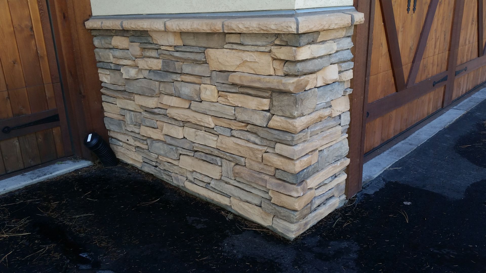 A stone wall with a wooden door in the background