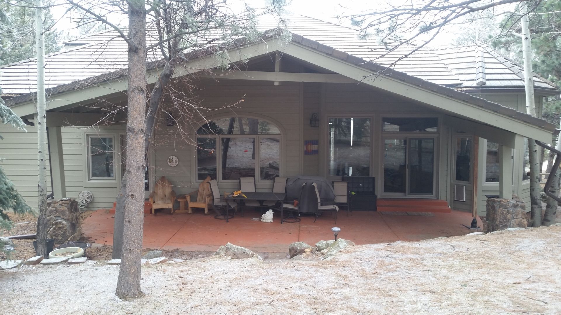 A house with a covered porch and trees in front of it