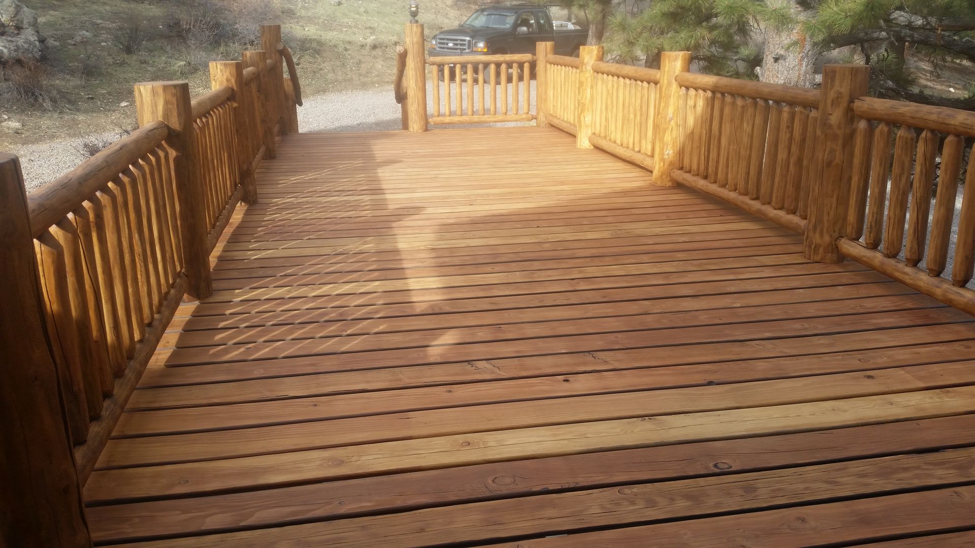 A wooden bridge with a car parked on the side of it.