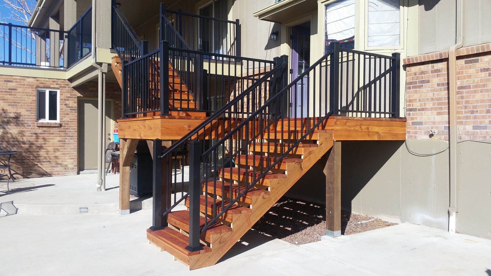 A wooden deck with stairs leading up to a house.