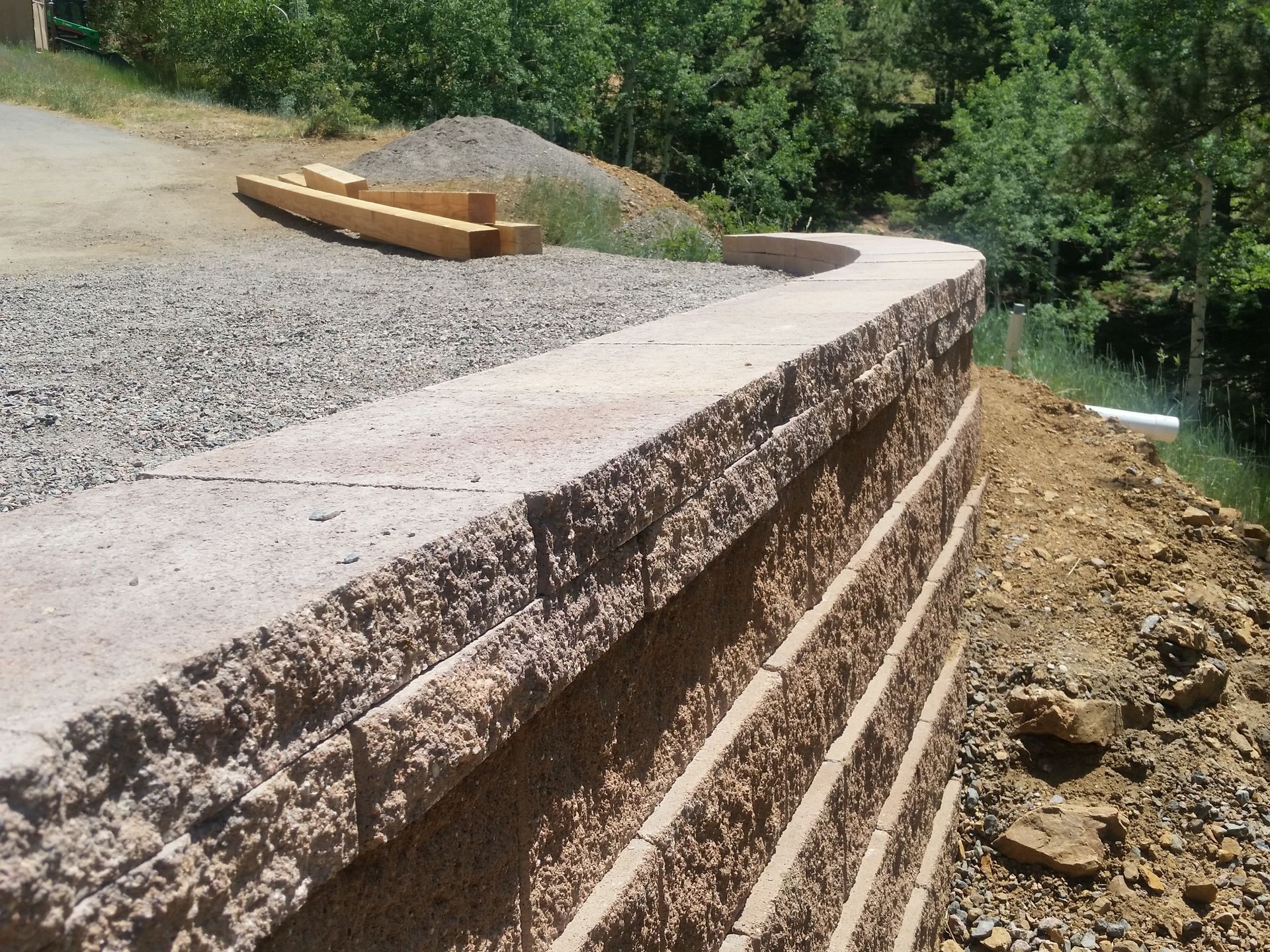 A brick wall is being built on a dirt hillside