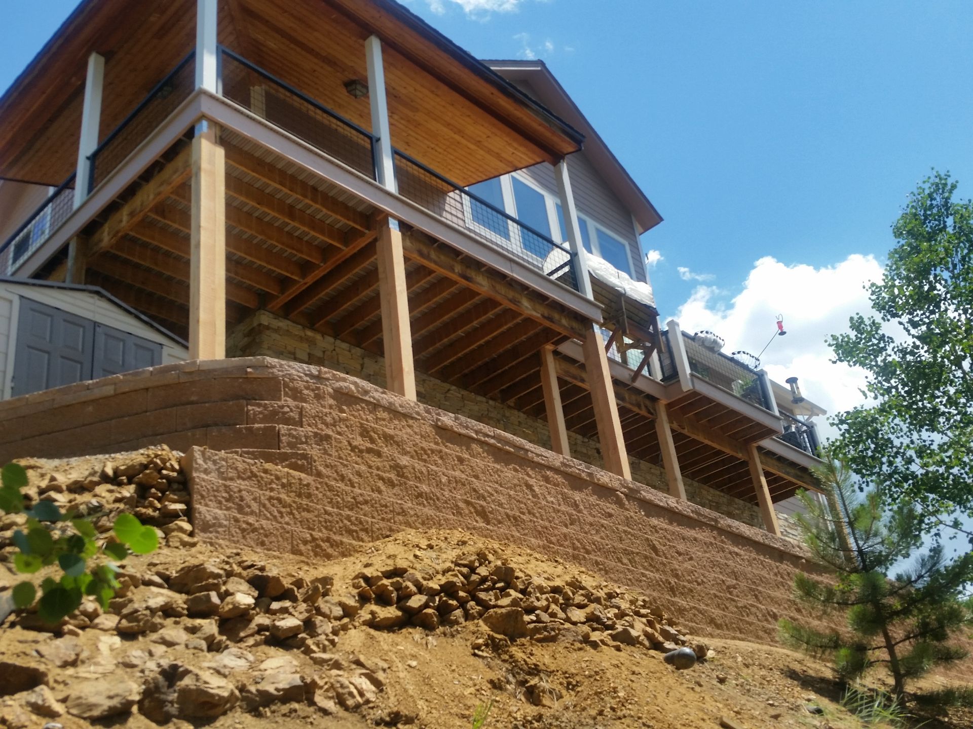 A large house is sitting on top of a rocky hill.