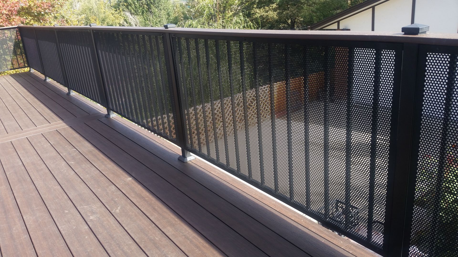 A black metal fence surrounds a wooden deck