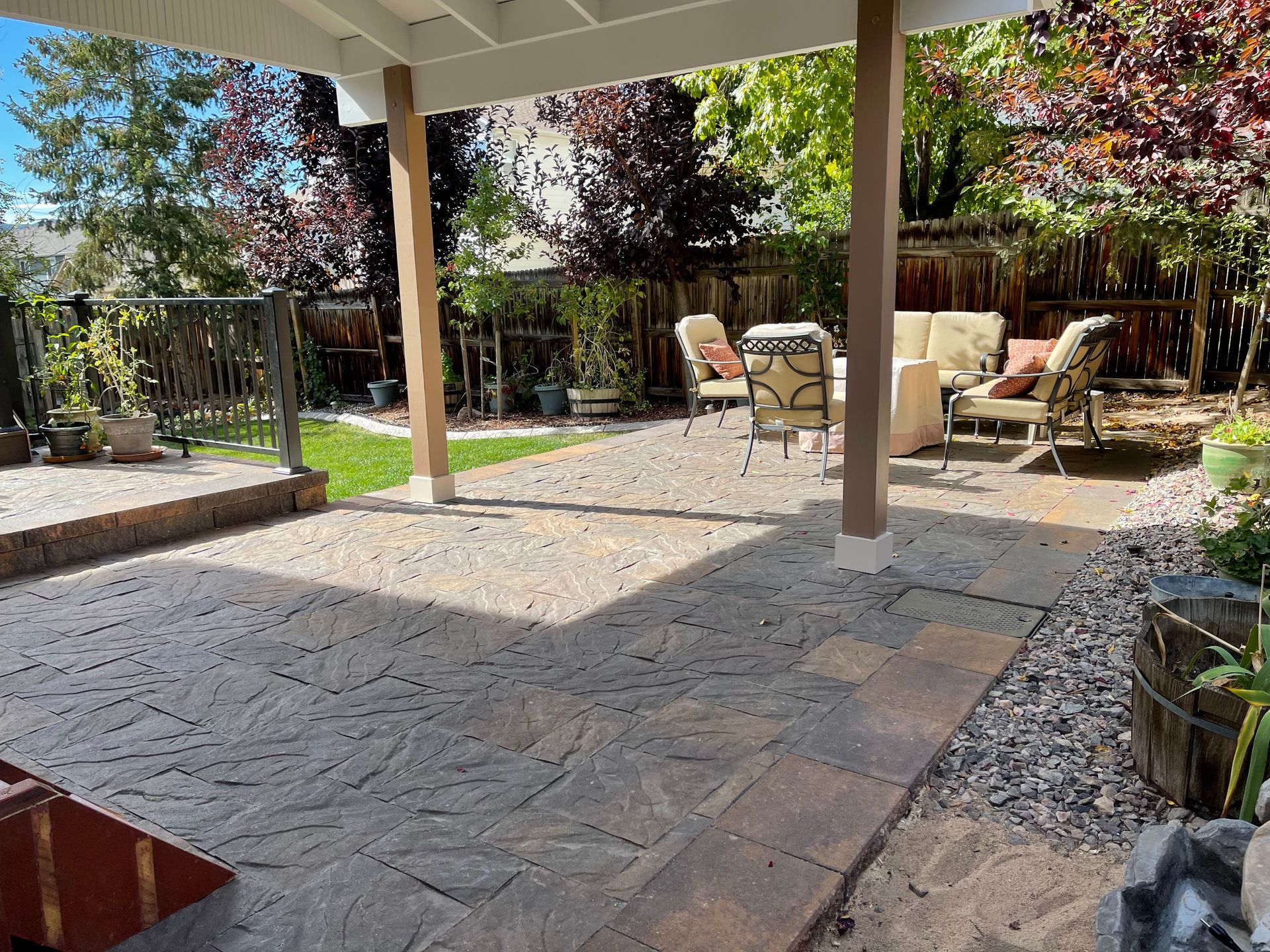 A patio with a couch and chairs under a canopy.