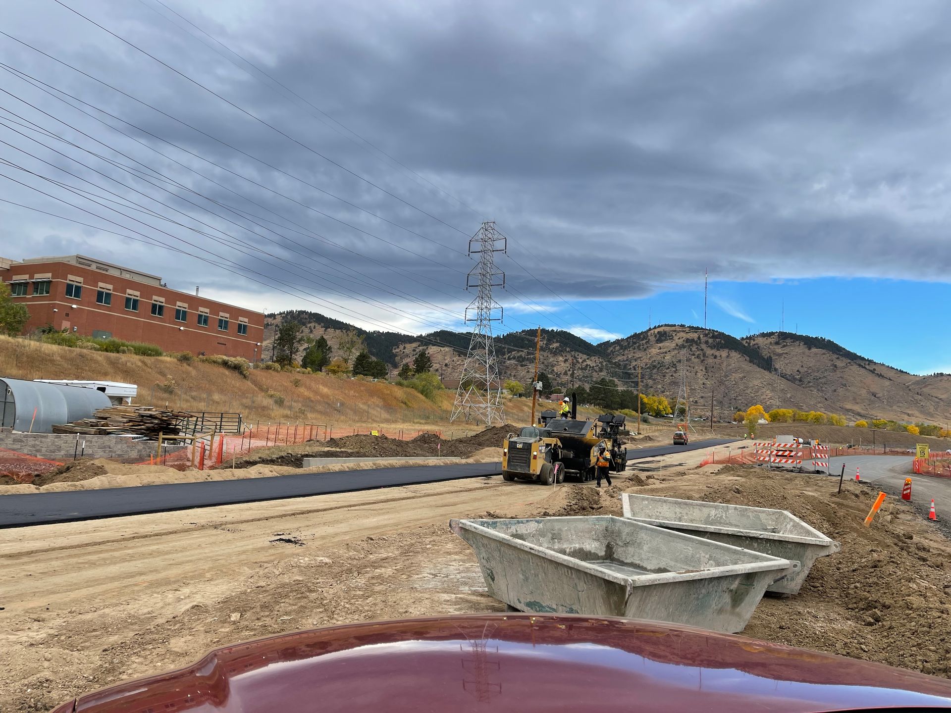 A construction site with a building in the background and mountains in the background