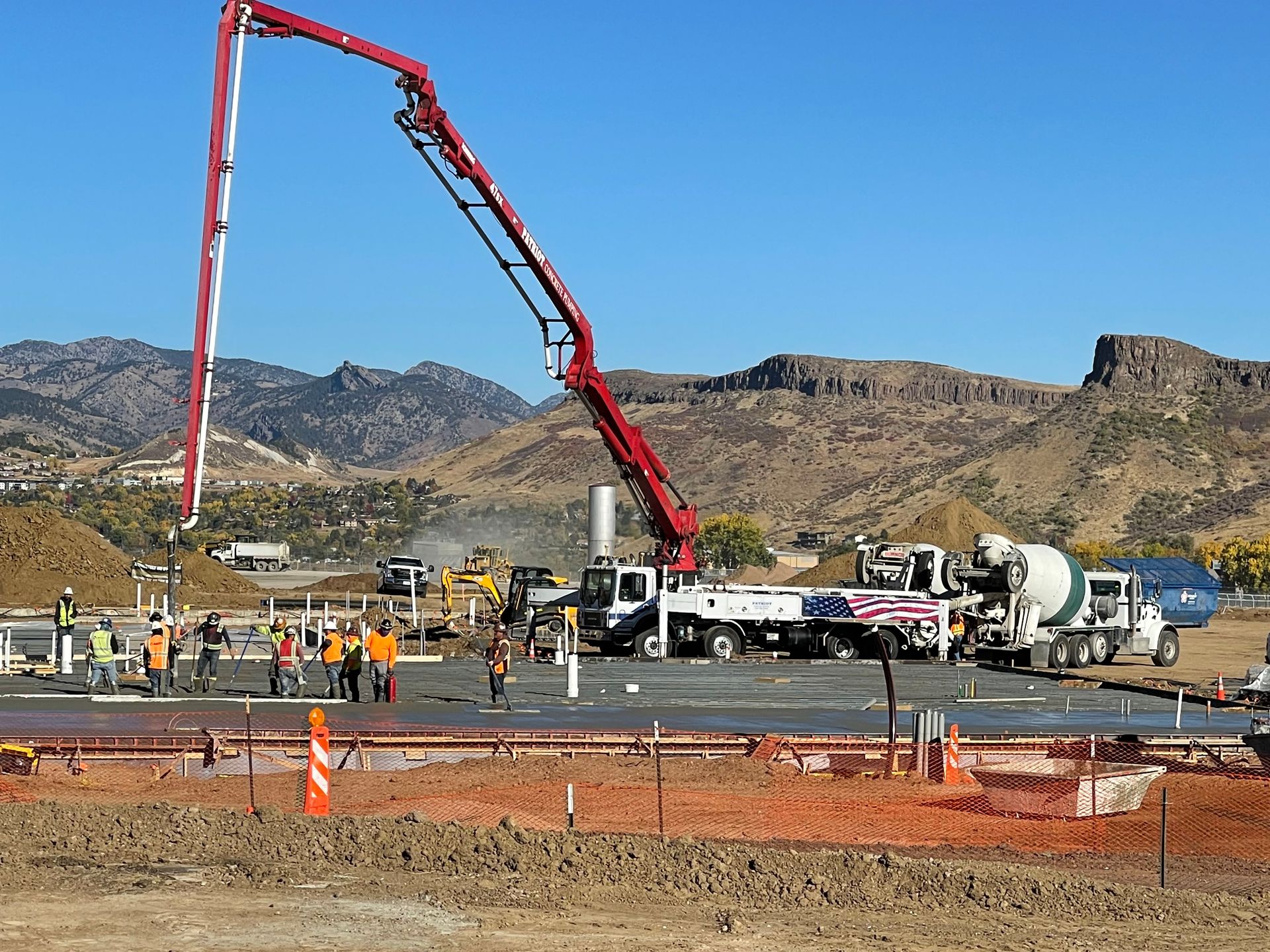 A concrete pump is being used to pour concrete on a construction site.