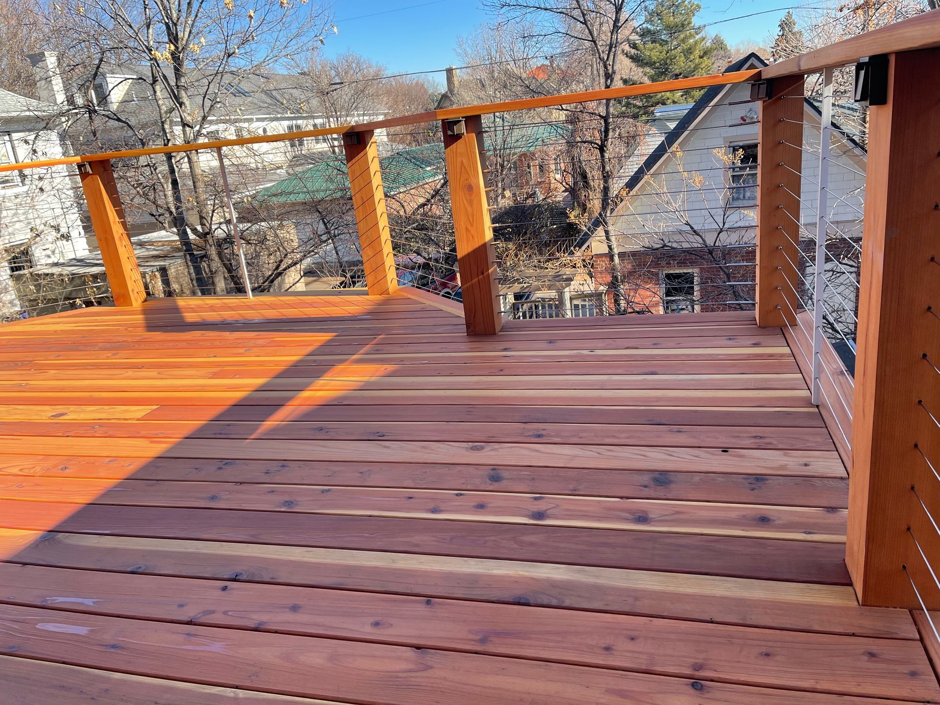 A wooden deck with a rope railing and a view of a city.