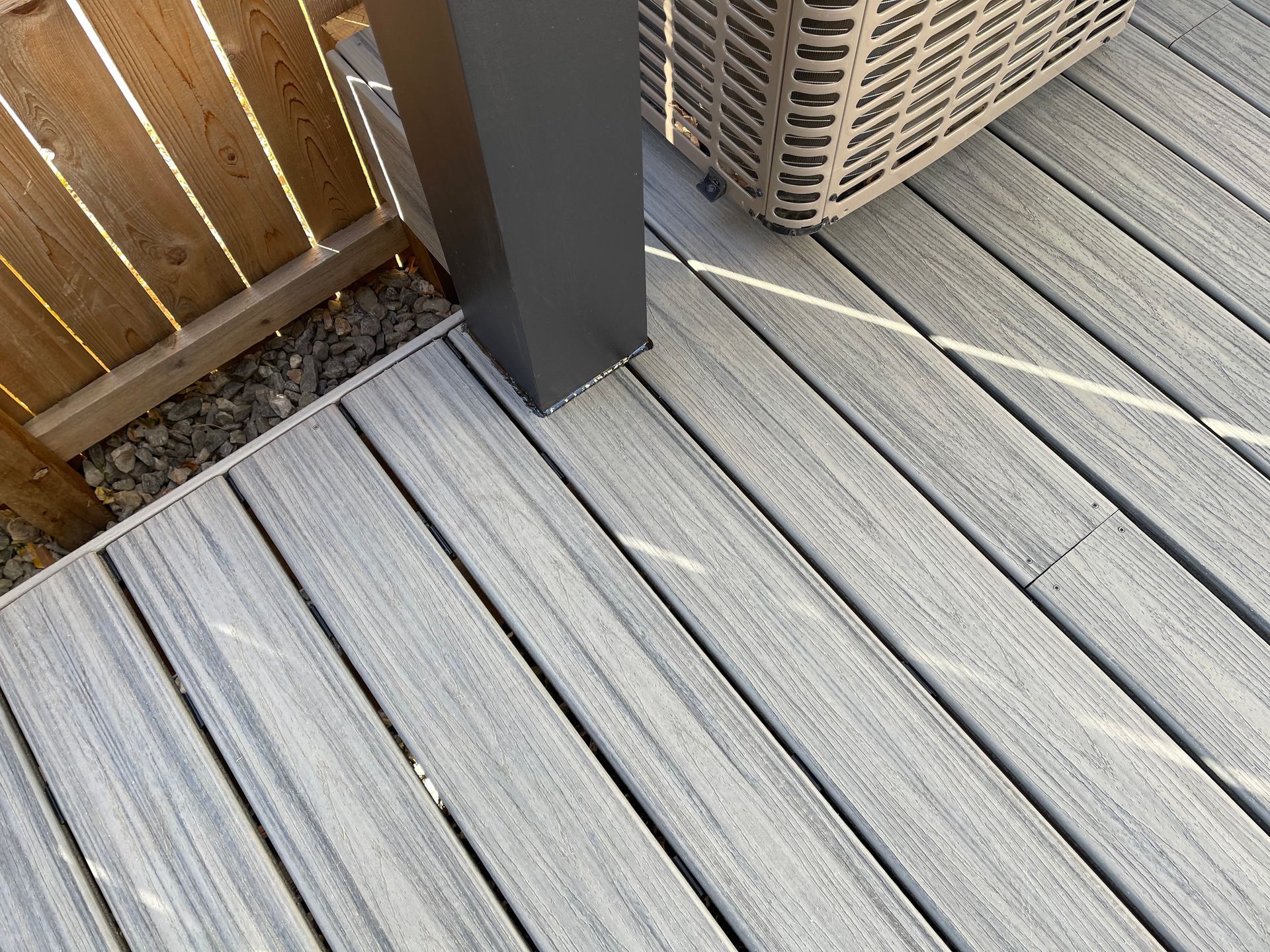 A close up of a wooden deck with a fence in the background.