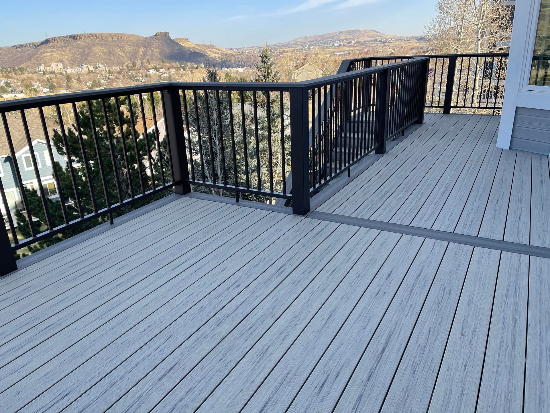 A large deck with a railing and a view of a city.