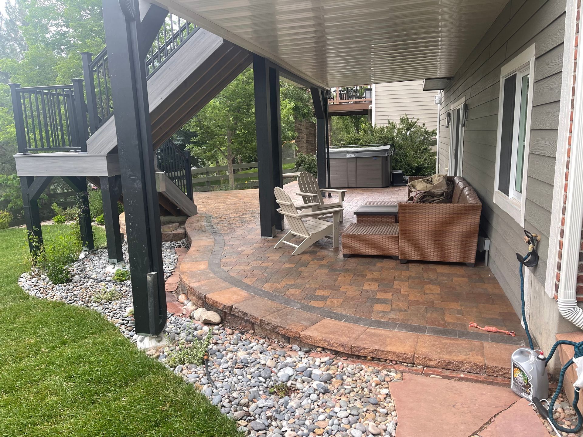 A house with a patio and a hot tub underneath it.