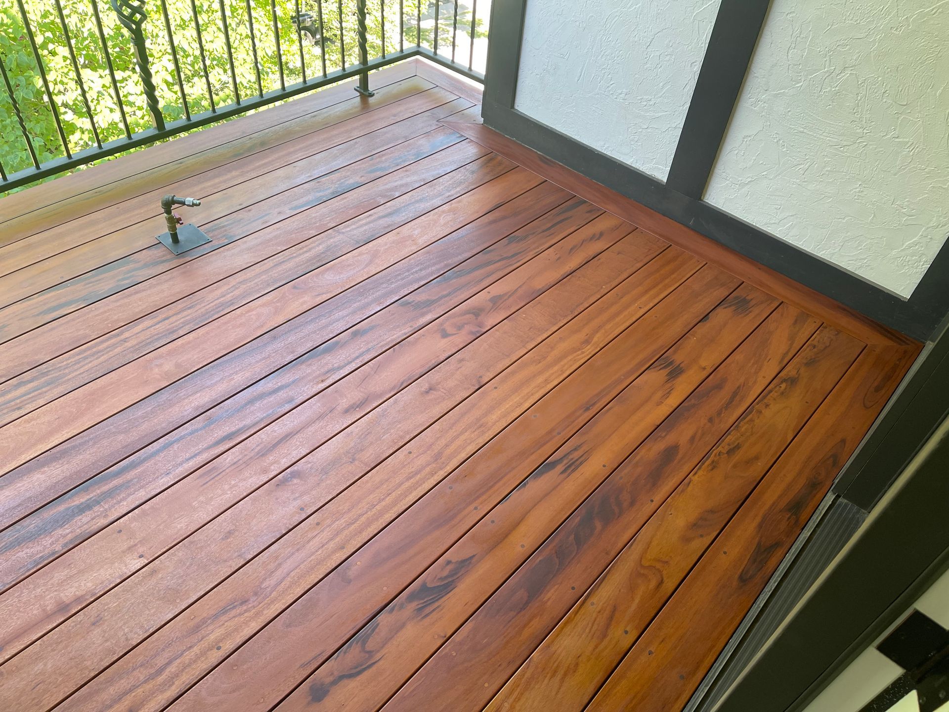 A balcony with a wooden deck and a metal railing