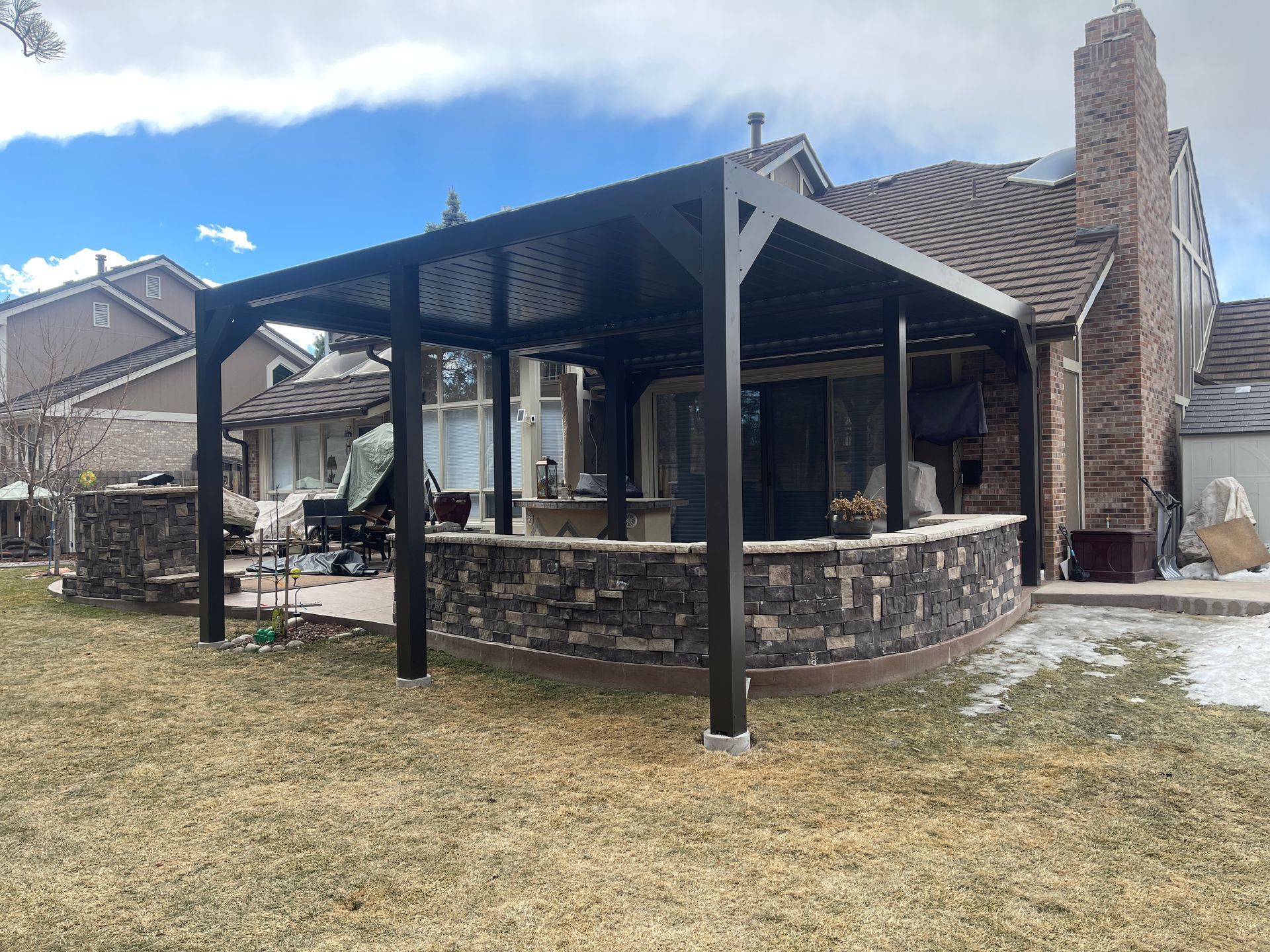 A house with a patio and a pergola in front of it.