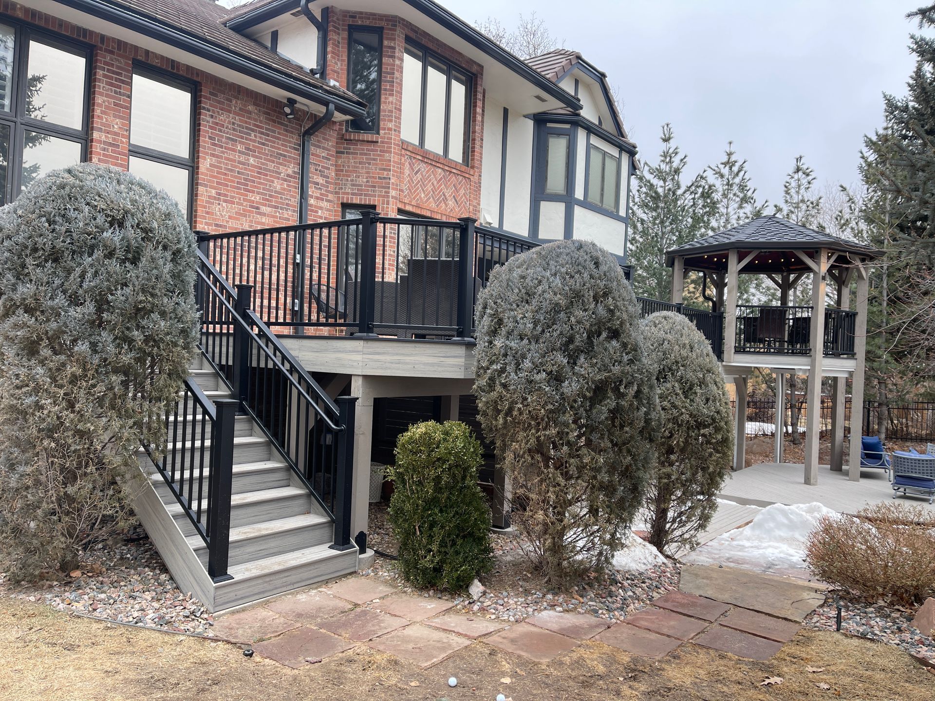 A large house with a deck and stairs leading up to it.