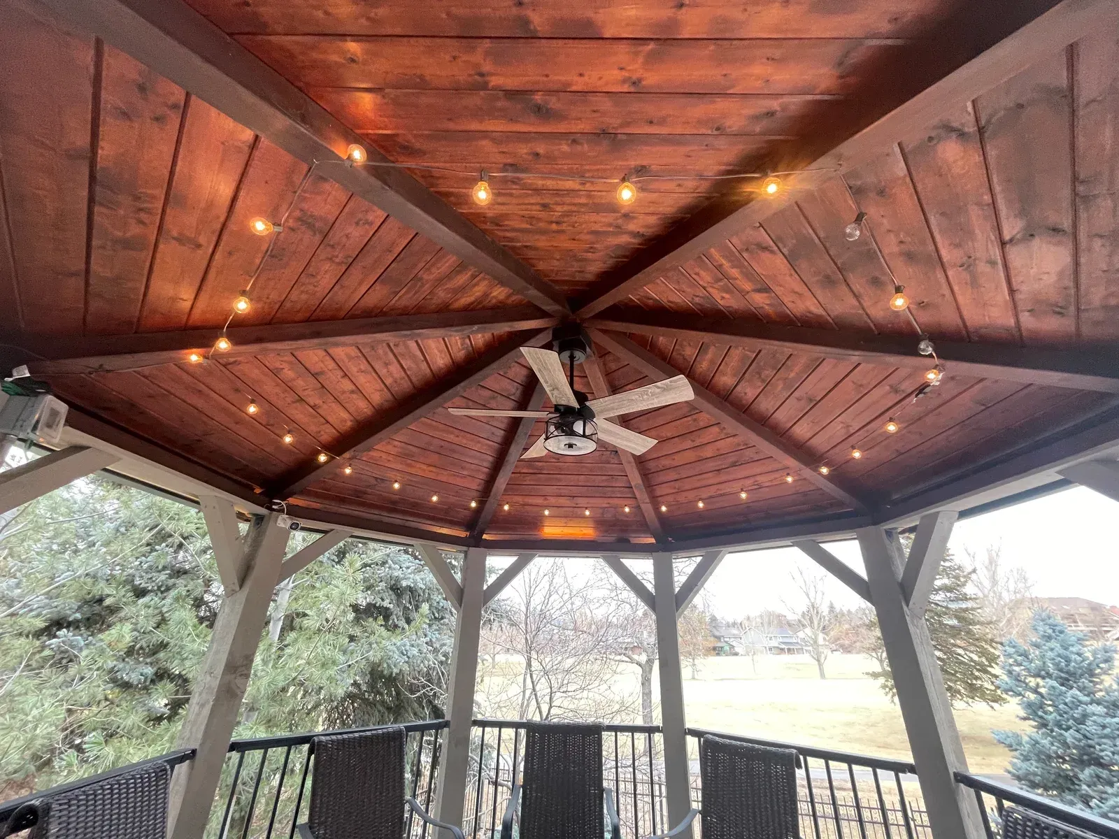 A gazebo with a ceiling fan and lights on it.