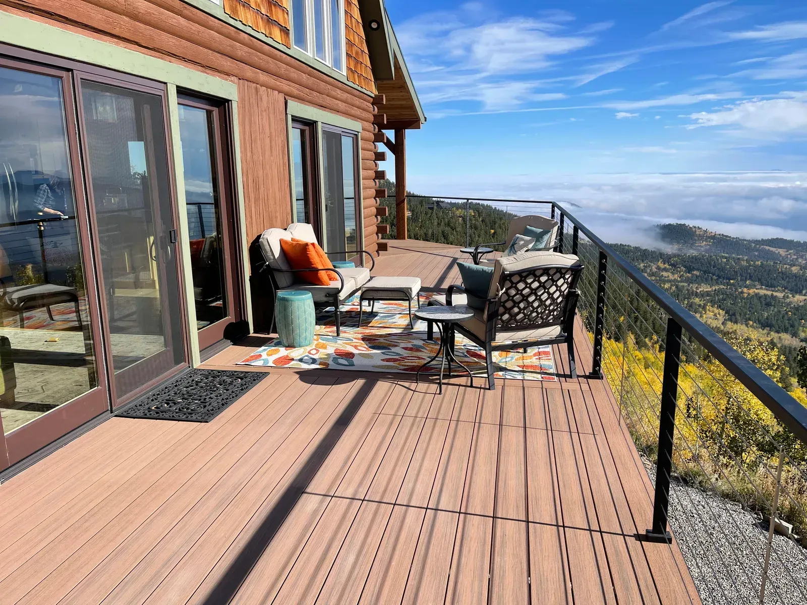 mountain view from a composite deck with a black metal railing attached to a log cabin. Amazing View