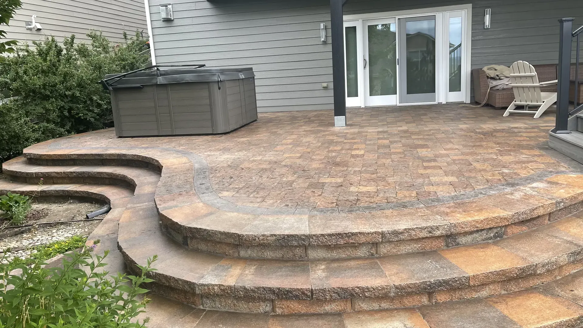 Paver patio with stone steps and hot tub built by Deck Doctor Inc in Morrison CO