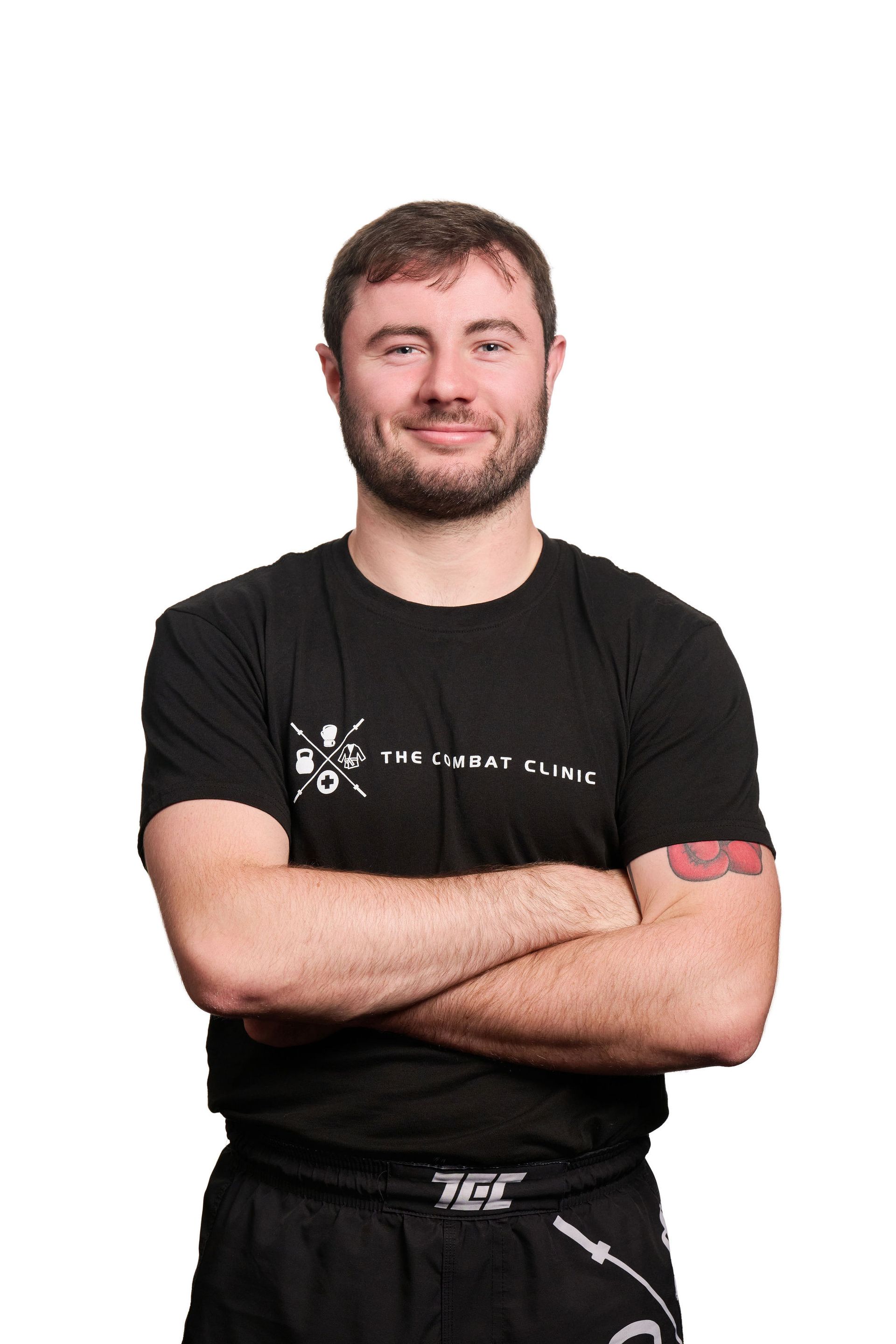 Man with tattoos smiles, stands beside