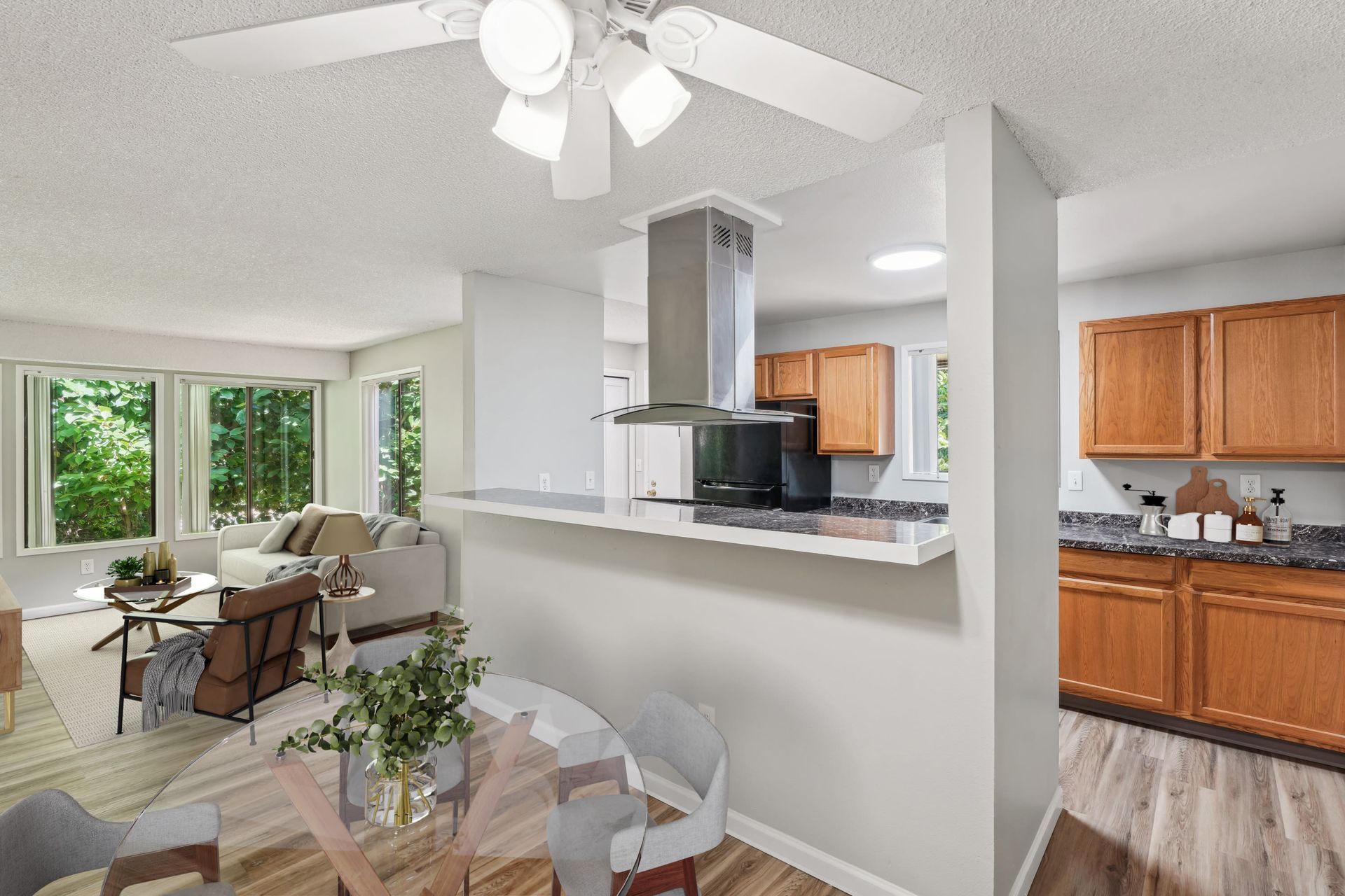 Open-concept living area with a kitchen, breakfast bar, and large windows.