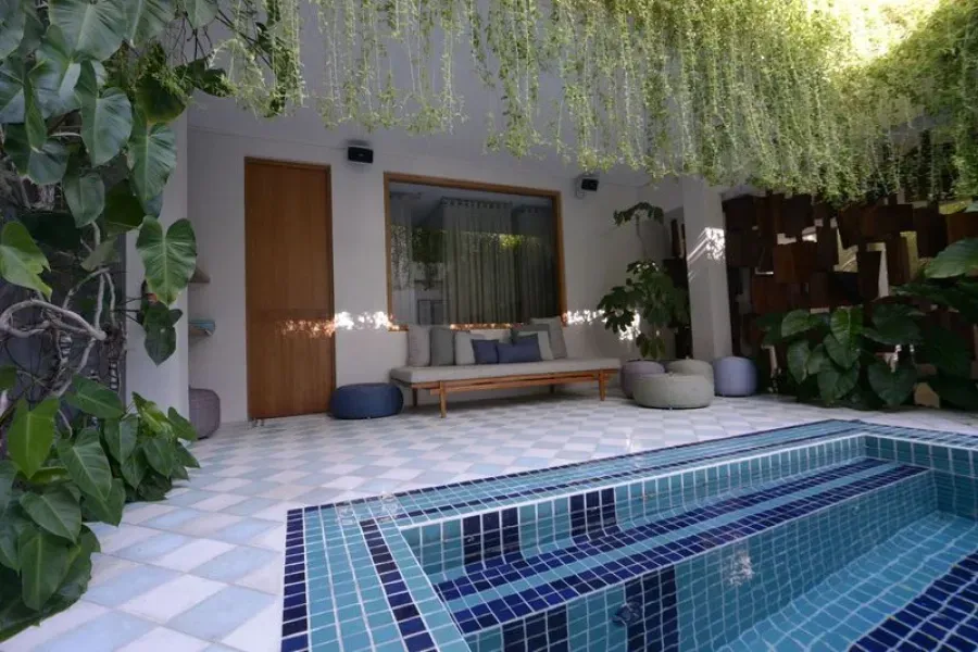 There is a swimming pool in the backyard of a house.