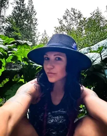 A woman wearing a hat with a blue flower on it