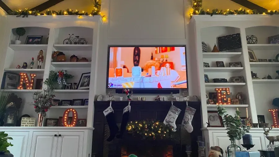 A living room with a fireplace and a flat screen tv.