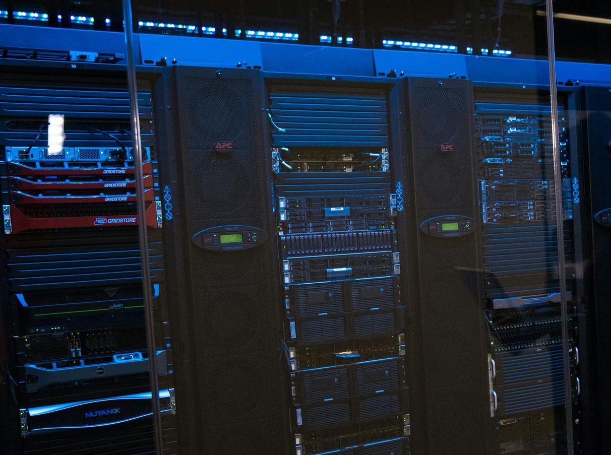 A row of servers are lined up in a dark room