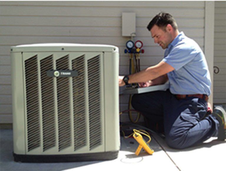 Staff Fixing AC — Kalamazoo, MI — Suburban Heating & Air Conditioning