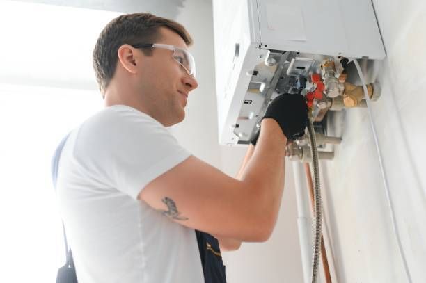 Professional boiler service: a qualified technician checking a natural gas boiler at home.