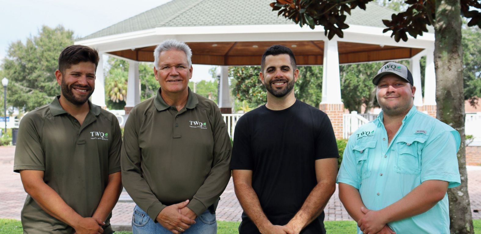 A group of men are posing for a picture in front of a gazebo.
