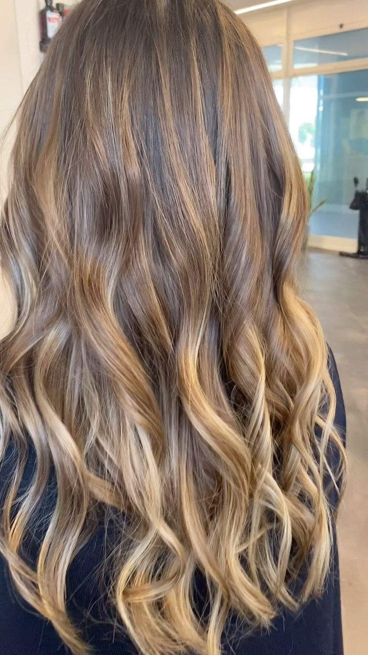 Un primo piano dei capelli lungi mossi e sfumati di biondo