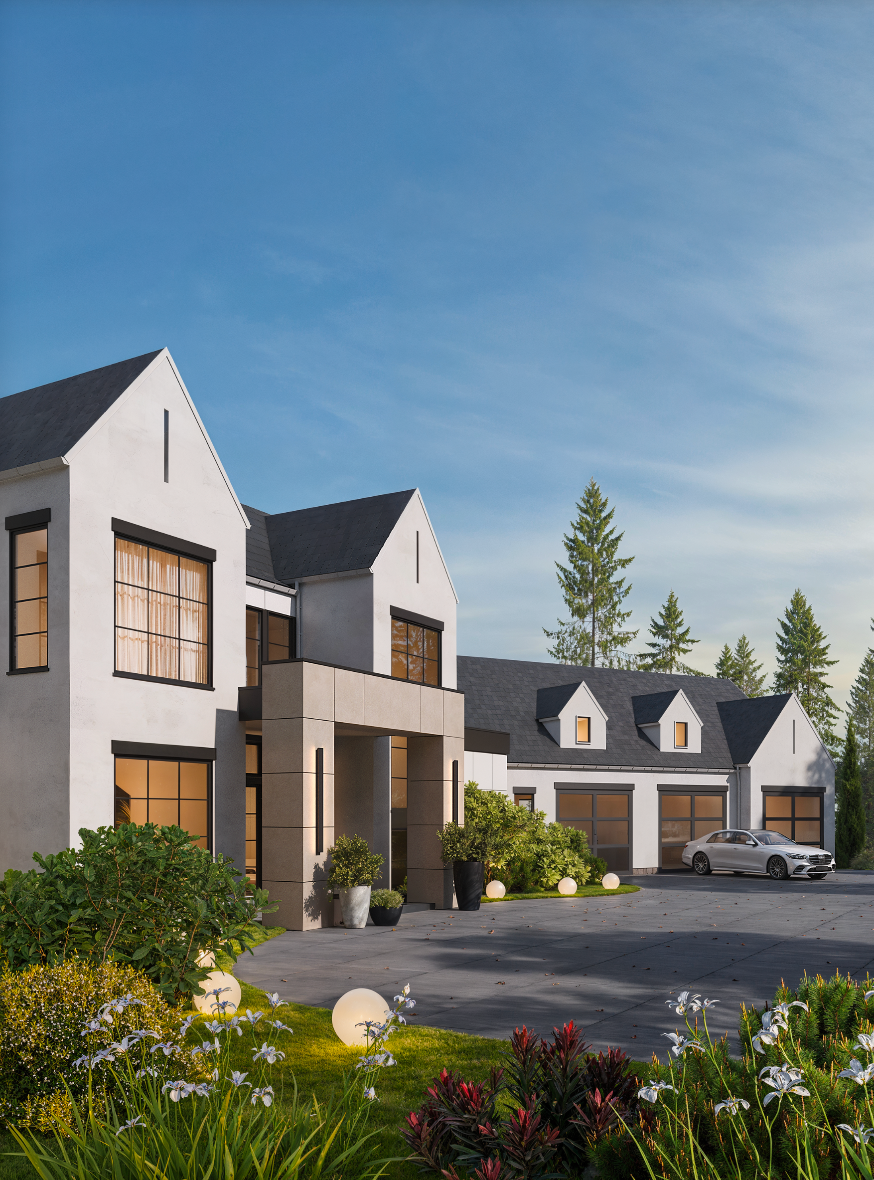 A modern white multi-story house with dark roofs, a stone entryway, and a driveway with a car in front of a forest.
