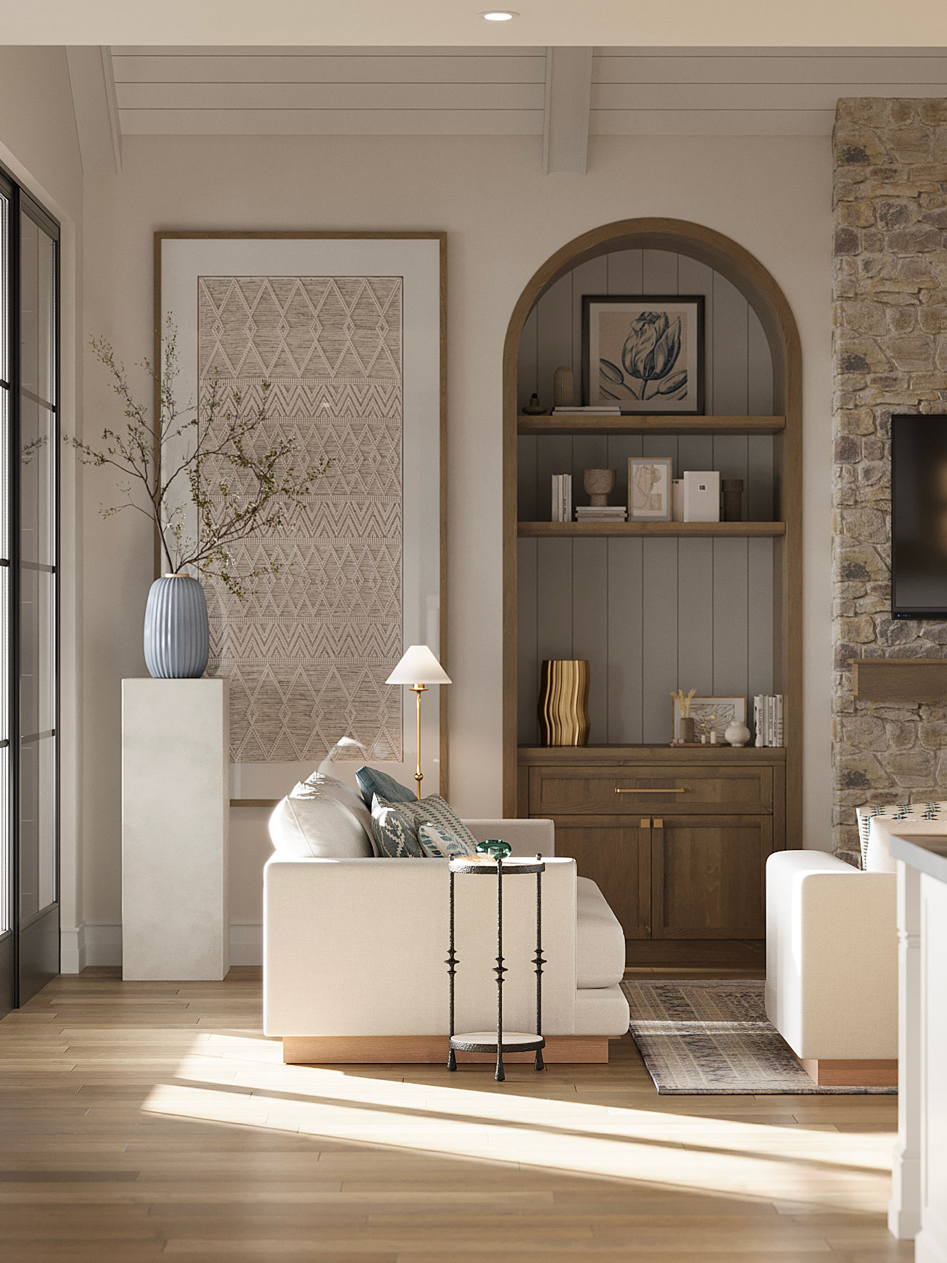 A sunlit living room features cream furniture, a stone fireplace, and a wooden arched bookshelf with neutral decor.
