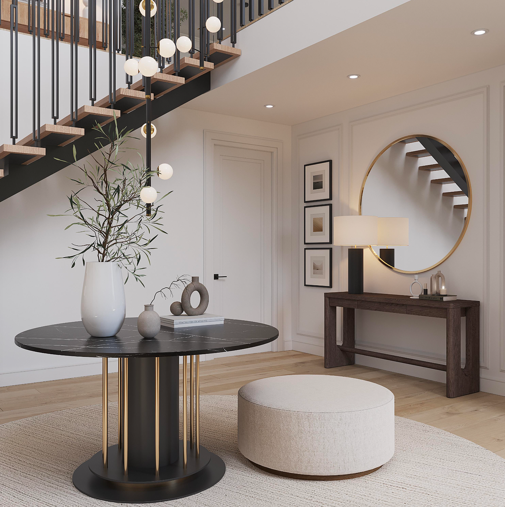 A modern foyer features a round marble pedestal table, a cream ottoman, and a dark wood console table with a round mirror.