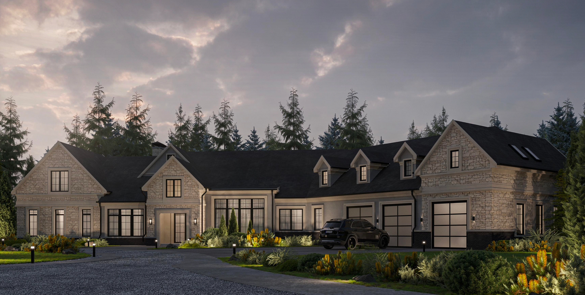 A large, multi-gabled, light-stone house with dark trim and a gravel driveway at twilight, surrounded by tall pine trees.