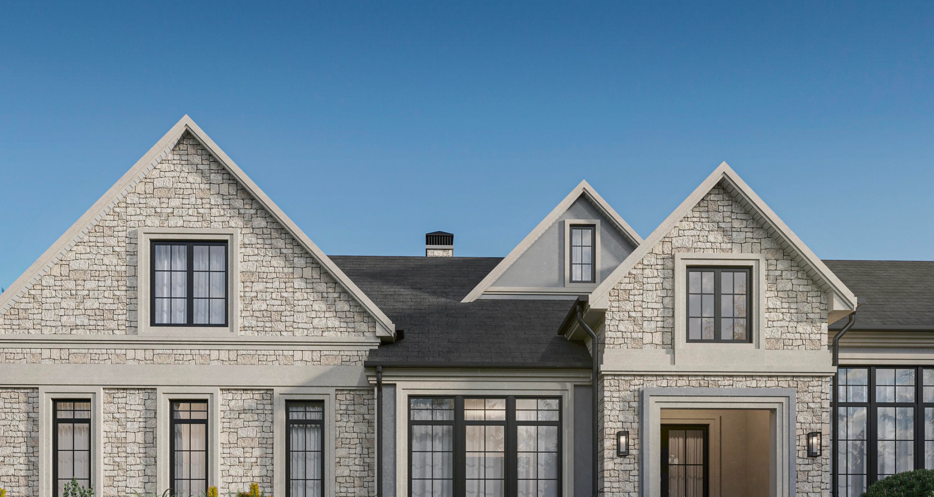 A stone-clad house exterior with multiple gabled roofs, dark-framed windows, and a clear blue sky background.