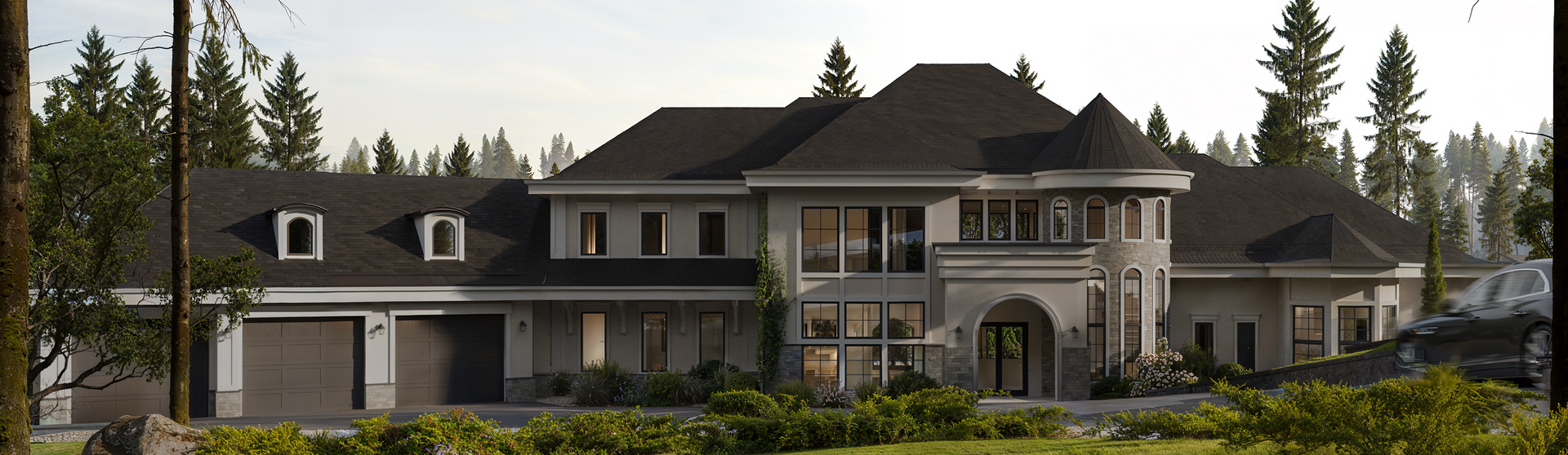 A wide, two-story luxury house with dark gray roofing, a turret, and an attached three-car garage in a forested setting.
