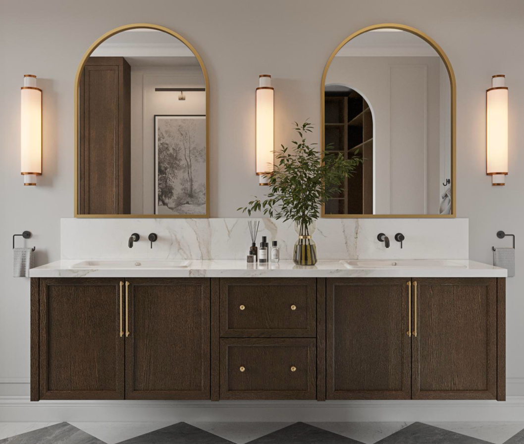 A double bathroom vanity with dark wood cabinets, white marble countertops, and two arched gold-framed mirrors.