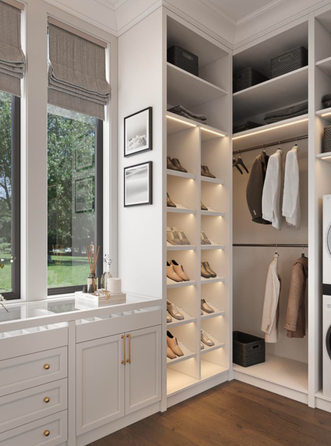 A bright, modern laundry room featuring white cabinetry, illuminated open shelving for shoes, and a hanging closet area.