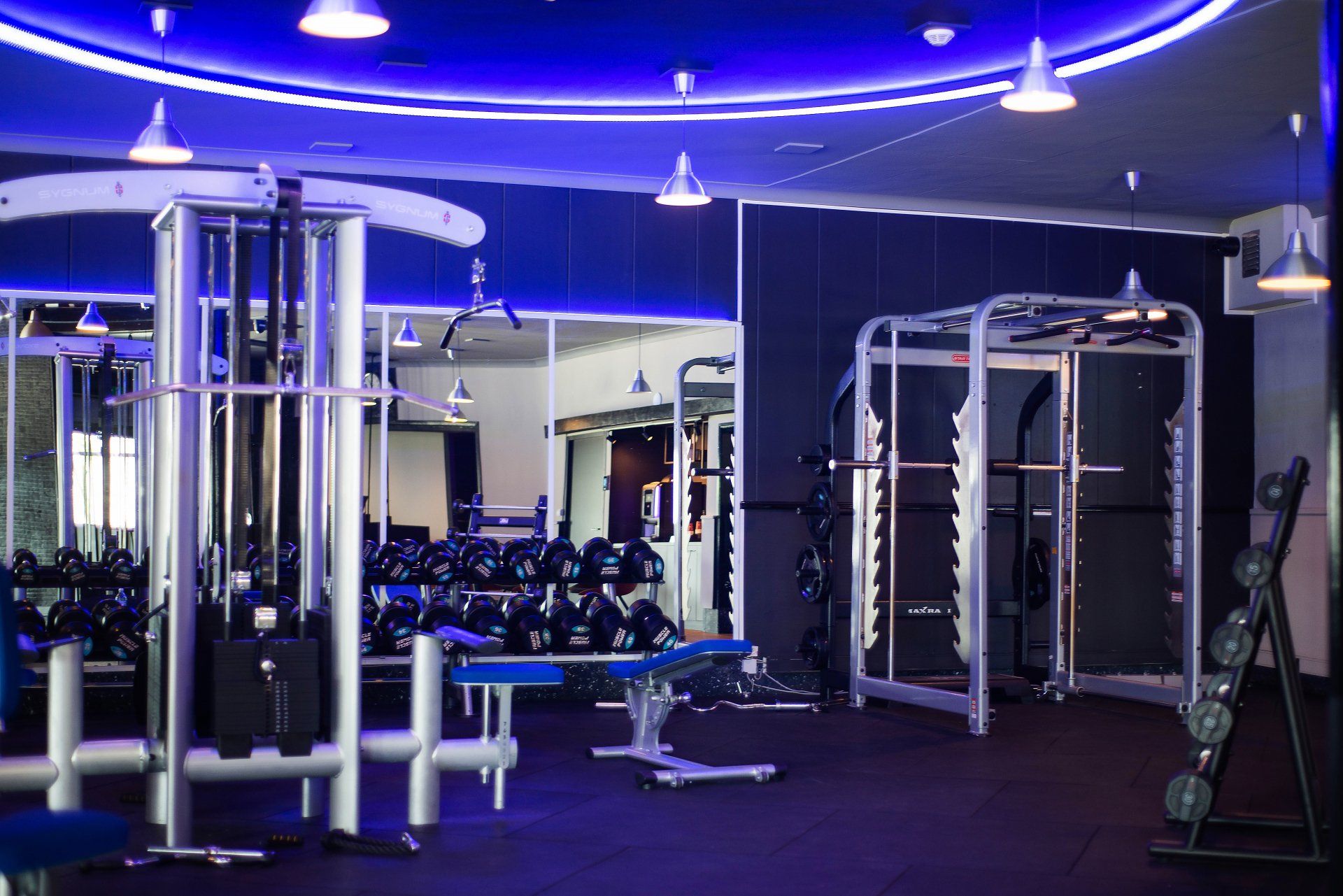 een fitnessruimte met veel apparatuur en een blauw plafond.