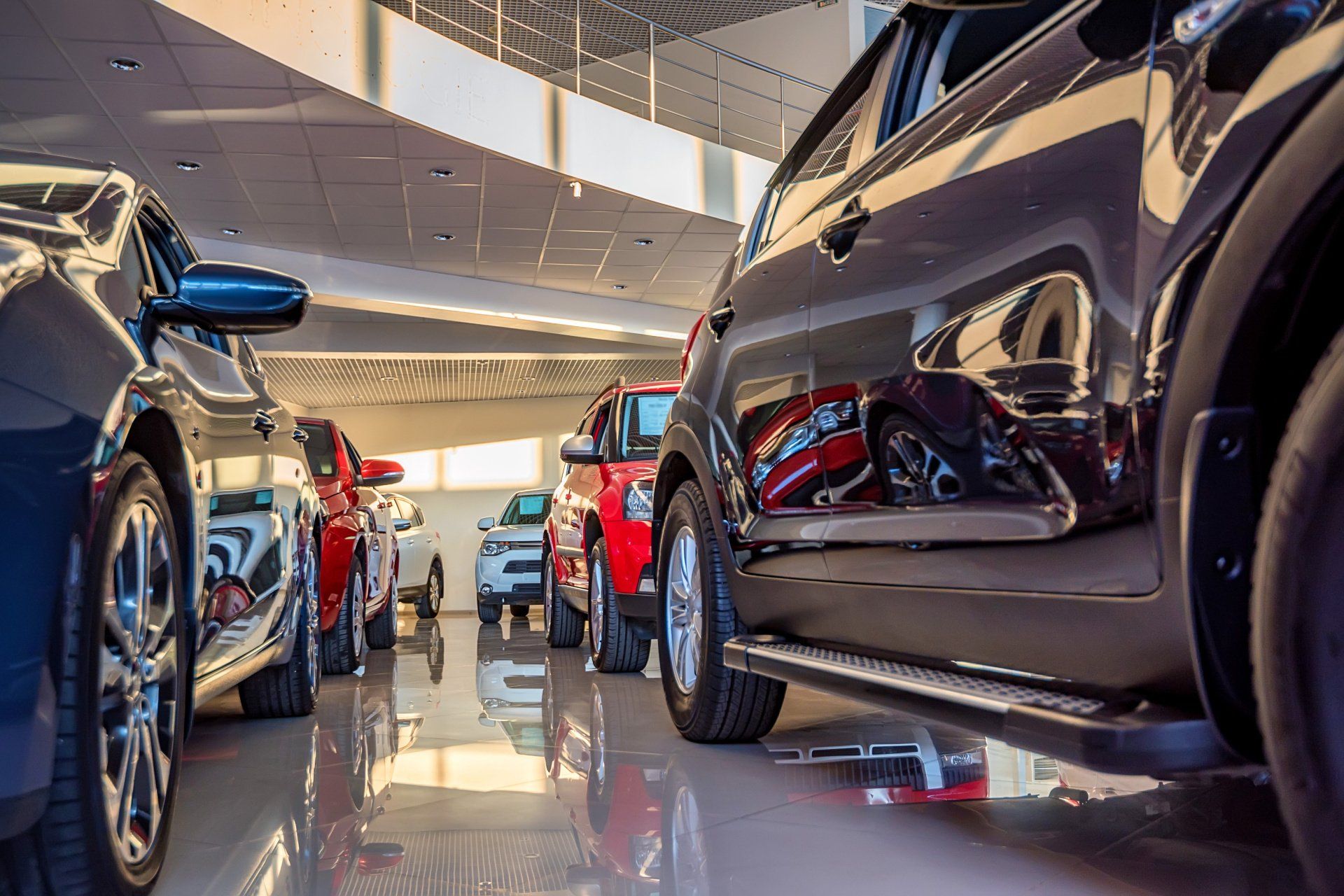 Cars parked inside a brightly lit dealership showroom.