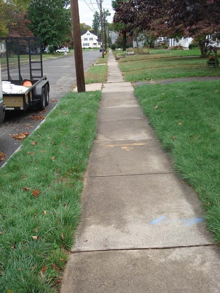 A sidewalk with a trailer parked on the side of it