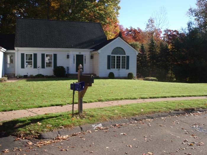 A white house with a blue mailbox in front of it