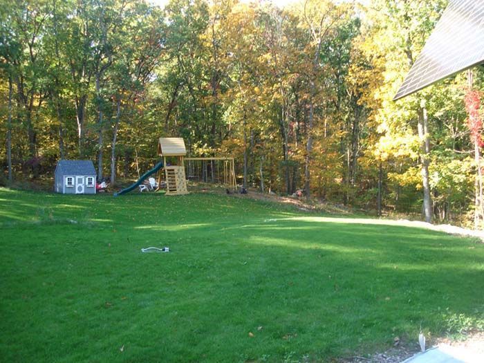 A backyard with a playground in the middle of it