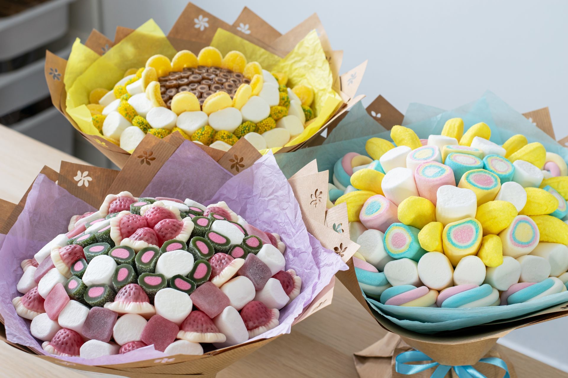 Three bouquets of candy are sitting on a table.